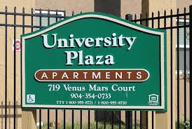 A sign for University Plaza Apartments with contact information.